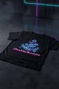 Camiseta negra con el logo neón El Ancla Creativa y la frase Firme en la tierra, libre en el universo con borde rosa